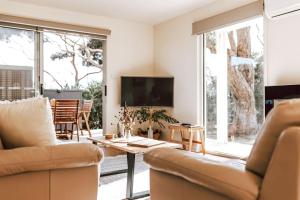 a living room with a couch and a table at Cod Rock Point in Bicheno