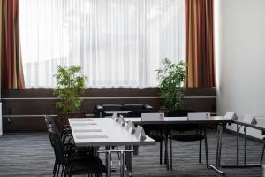 a dining room with tables and chairs and windows at Best Western Plus Plaza Hotel Graz in Graz