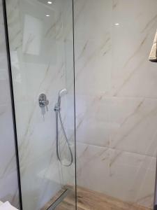 a bathroom with a shower with a glass door at White Boutique Homes - Euphoria in Metókhion Apisianá