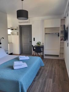 Un dormitorio con una cama azul con toallas. en White Boutique Homes - Euphoria, en Metókhion Apisianá