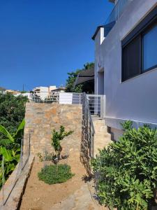 a stone retaining wall next to a house at White Boutique Homes - Euphoria in Metókhion Apisianá