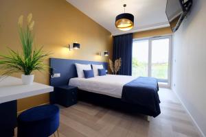 a bedroom with a large bed with a blue headboard at Apartamenty Centrum Premium Gold in Białystok