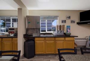 a large kitchen with wooden cabinets and a refrigerator at Quality Inn & Suites Medford Airport in Medford