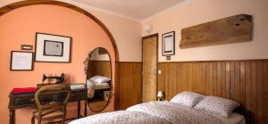1 dormitorio con cama, escritorio y espejo en Sintra Small Hostel, en Sintra