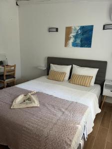 a bedroom with a large bed with a blanket at Agrielia Seafront Katigiorgis, Agios Georgios, Pelion in Agios Georgios