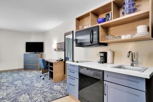 eine Küche mit einem Waschbecken und einem Schreibtisch in der Unterkunft Candlewood Suites Atlanta West I-20, an IHG Hotel in Lithia Springs