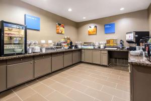 a large kitchen with a counter top with food at Comfort Inn & Suites IAH Bush Airport - East in Humble