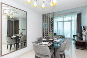 a dining room with a table and chairs and a mirror at Stylish Apartment With Incredible Canal Views in Dubai