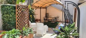 un patio esterno con sedie e piante bianche di Sea and Blue Sky 2-A a Calimera