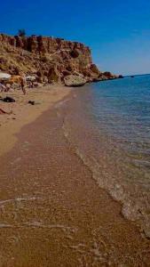 a beach with the ocean and a rocky shoreline at Duplex Casa uso esclusivo Wi-Fi e spiaggia vicino in Sharm El Sheikh