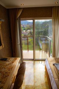 una camera da letto con porta scorrevole in vetro che si apre su un balcone di Luxury Apartments 'Rich' a Velingrad