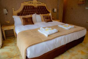 een slaapkamer met een groot bed en handdoeken bij Luxury Apartments 'Rich' in Velingrad