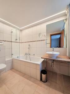 y baño con bañera, lavabo y aseo. en Self service Guesthouse Berggeist, en Saas-Fee