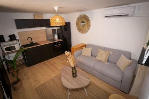 a living room with a couch and a table at Appartement boheme in Martigues