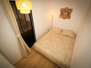Habitación pequeña con cama y ventana en Appartement boheme, en Martigues
