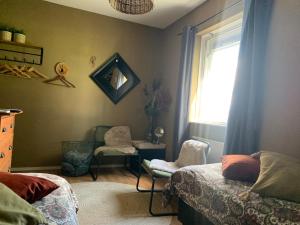 a bedroom with two beds and a window and a chair at Brinkesdiek in Hardenberg