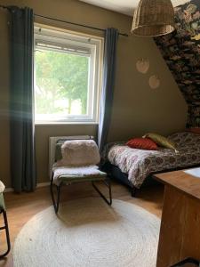 a bedroom with a bed and a window and a chair at Brinkesdiek in Hardenberg