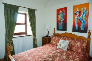 1 dormitorio con 1 cama con colcha roja y ventana en Gars Cottage - 3 Bedroom Holiday Home, en Kirkby Stephen
