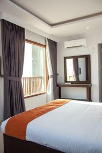 1 dormitorio con cama, ventana y espejo en Destination Beach Hotel by Dreamworld, en Karachi