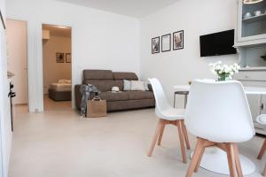 a living room with a table and white chairs at NTARTEI in Matino