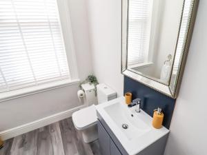 a bathroom with a white sink and a mirror at Apartment 4 in Grimsby