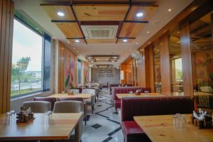 un ristorante con tavoli e sedie e una grande finestra di The Ekling Garh Hotel & Resort a Udaipur