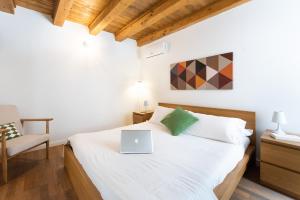 a bedroom with a bed with a laptop on it at Ortigia Suite - Theater in Syracuse