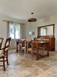 comedor con mesa, sillas y espejo en Maison au Jude en Lamothe-Landerron