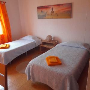Zimmer mit 2 Betten und einem Bild an der Wand in der Unterkunft Quarto duplo em Foros de Salvaterra in Estanqueiro