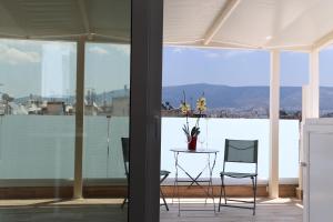 a room with a table and chairs and a large window at LIV - View and the City Studio in Athens in Athens