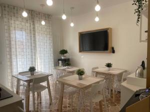 una sala da pranzo con tavoli e TV a schermo piatto di Ciccio Rooms and breakfast a Palermo