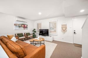 a living room with a brown couch and a table at Townhouse on The Hill in Newcastle