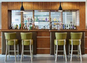 un bar con 4 taburetes de bar verde en Leonardo Hotel Bradford - formerly Jurys Inn, en Bradford