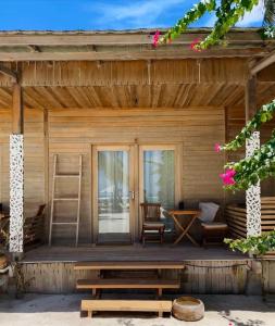 een veranda van een houten hut met een ladder bij Met House in Thulusdhoo