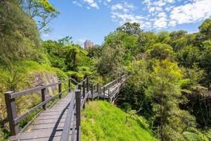 a wooden boardwalk leading down a hill with trees at Private Grannyflat Room In Maroubra in Sydney