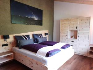 a bedroom with a large bed with a wooden headboard at Herzbluad Chalet in Wallgau
