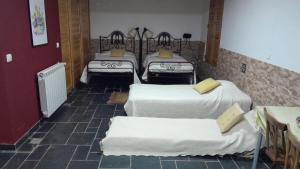 a room with four beds with white sheets at Casas da Nascente in Loriga