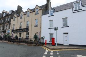 a row of buildings on the corner of a street at MacDonald House in Portree