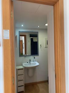 a bathroom with a sink and a mirror at Apartamento con encanto en la playa frente al mar "Posada Rent House" in Puerto del Rosario