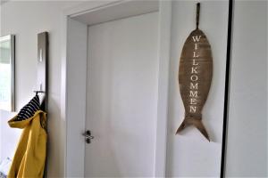 un poisson en bois suspendu à une porte dans une pièce dans l'établissement 47 2 M Seestern, à Wangerland