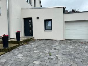 a white house with a door and a garage at Apartment am Deister in Barsinghausen