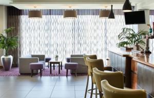 a waiting room with a bunch of chairs and tables at Leonardo Hotel Bradford in Bradford