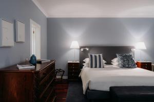 um quarto com uma cama grande e uma cómoda e candeeiros em Quinta São Gonçalo em Funchal