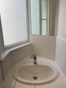 - białą umywalkę w łazience z lustrem w obiekcie St Martins w Londynie