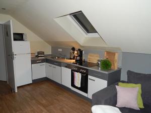 a kitchen with a stove top oven next to a couch at Grit´s Ferienwohnung in Ostseebad Karlshagen