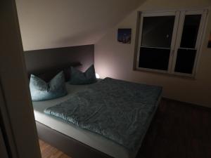 a bedroom with a bed with blue pillows and a window at Grit´s Ferienwohnung in Ostseebad Karlshagen