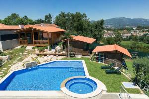 a backyard with a swimming pool and a house at Fernandes Guest House Green Bungalow in Ponte de Lima