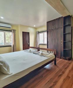 1 dormitorio con 1 cama grande y suelo de madera en Blue Door, en Bundi