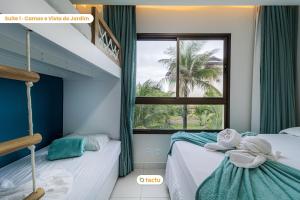 クムブコにあるApartamento gigante VG Sun Cumbuco por Tactuのベッドルーム1室(二段ベッド2台、窓付)が備わります。