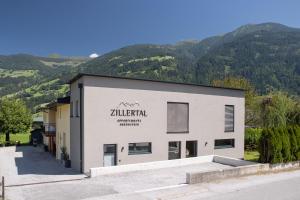 un edificio con un cartel en el costado en Zillertal Appartements, en Fügen